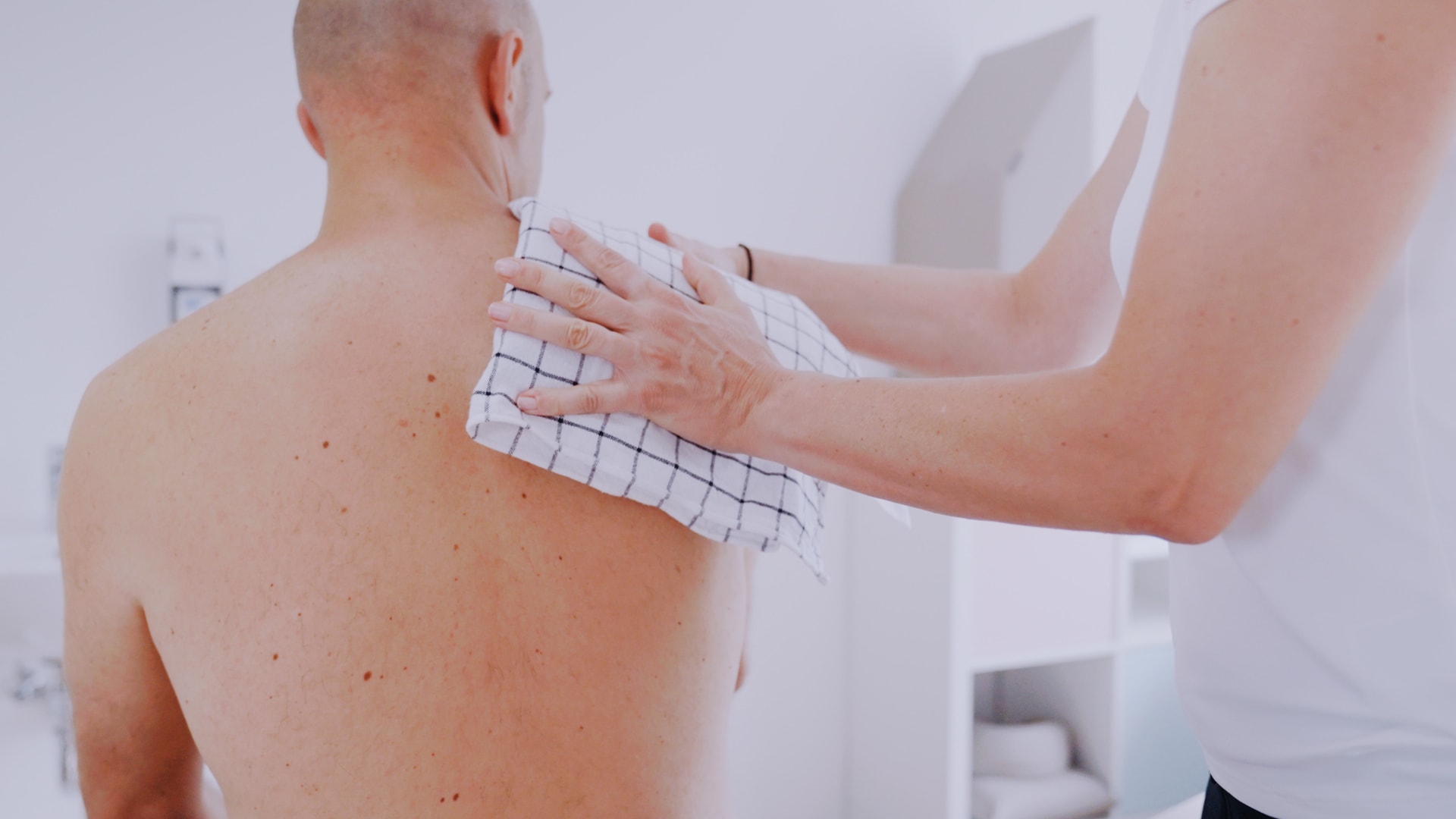 Kältetherapie an der rechten Schulter eines Patienten im Rahmen der physiotherapeutischen Behandlung in Köln