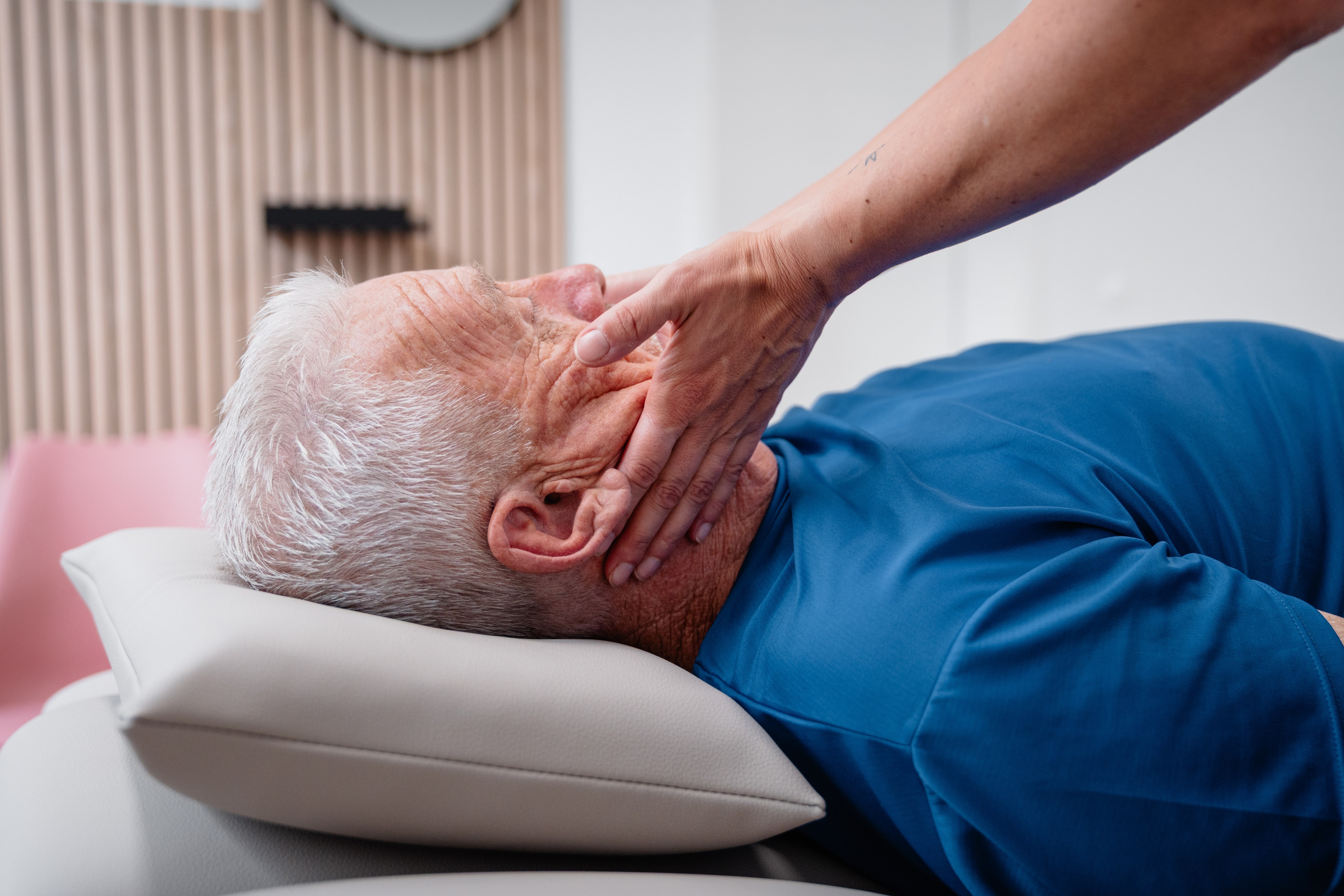 Manuelle Lymphdrainage am Hals des Patienten in der Praxis Inphynity Physio in Köln