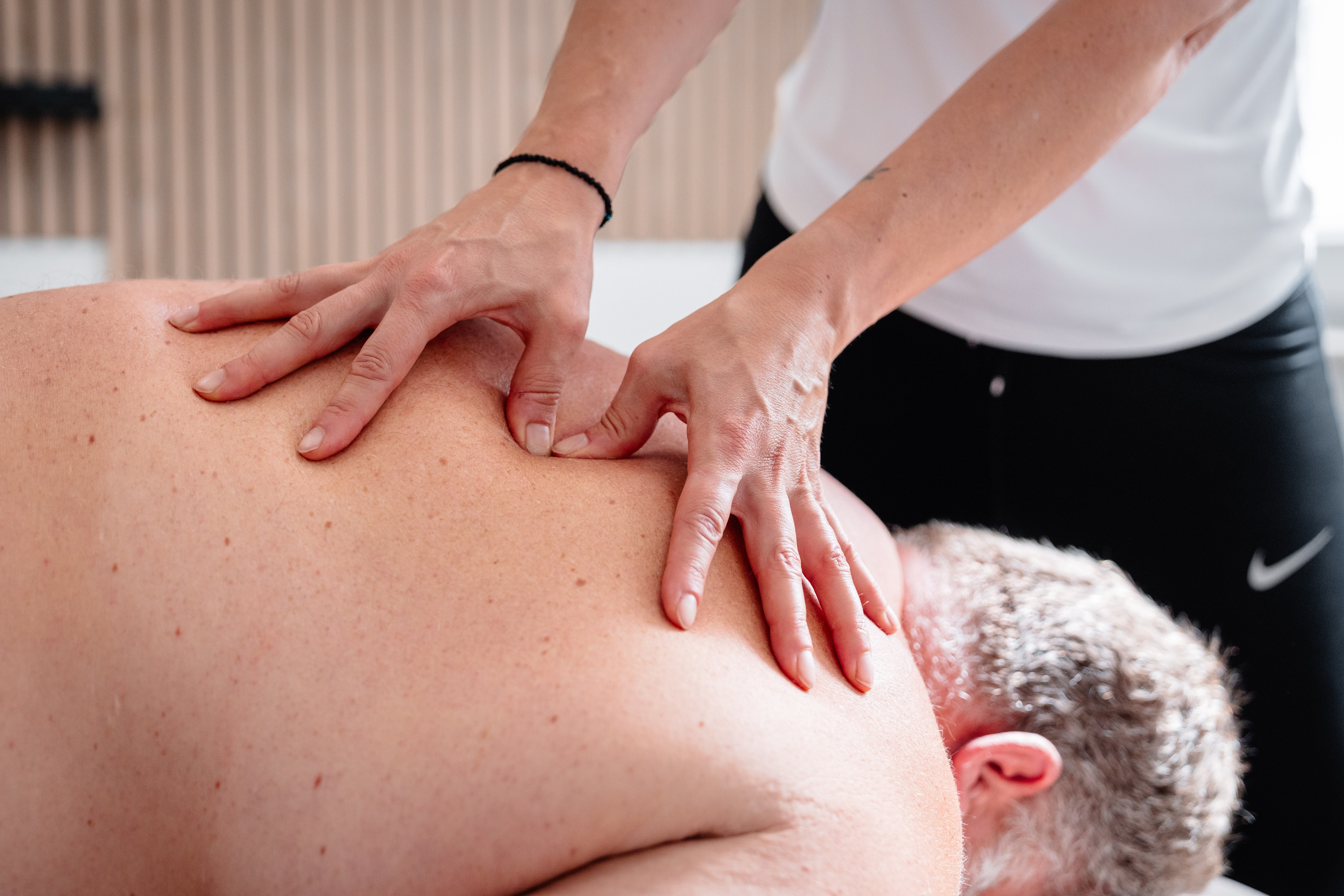 Patient erhält Wellnessmassage am Rücken zur Entspannung in der Physiotherapiepraxis Inphynity Physio in Köln